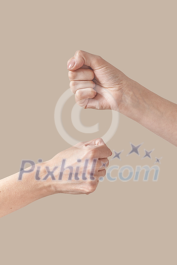 Man and woman hands fist bump alternative symbol of friendship isolated on beige background. Brotherhood awesome fists bump as agreement. Man and woman hands fist bump alternative symbol of friendship isolated on beige background. Brotherhood awesome fists bump as agreement.
