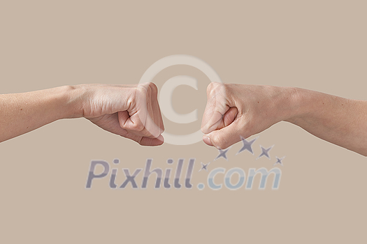 Two hands male and woman fist bumping symbol of friendship, good job, great work isolated on beige background. Brotherhood awesome fists bump as agreement. Two hands male and woman fist bumping symbol of friendship, good job, great work isolated on beige background. Brotherhood awesome fists bump as agreement.