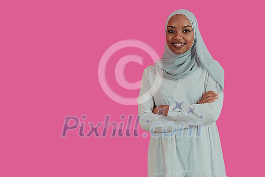 Portrait of young modern Muslim African beauty wearing traditional Islamic clothes on plastic pink background. Selective focus. High-quality photo