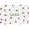 ADHD word formed of scrabble blocks and pharmaceutical pills strewn over white background. Attention deficit hyperactivity disorder and mental health awareness.