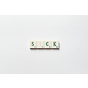 Sick word formed of scrabble blocks on white background. Sickness prevention and physical health awareness.