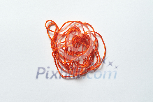 Red tangled thread on white background. Anxiety and mental health awareness.
