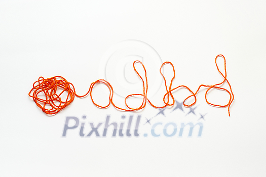 ADHD abbreviation formed of red tangled thread on white background. Attention deficit hyperactivity disorder and mental health awareness. ADHD abbreviation formed of red tangled thread on white background. Attention deficit hyperactivity disorder and mental health awareness.