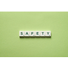 Safety word formed of scrabble tiles on green background.