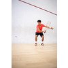 Squash player in action on a squash court (motion blurred image; color toned image)