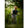 Young man with his mountain bike going for a ride past the city limits in a lovely forest, getting the daily cardio dose