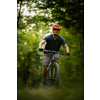 Young man with his mountain bike going for a ride past the city limits in a lovely forest, getting the daily cardio dose