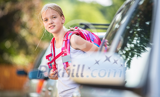 Cute little girl going home from school, looking well before crossing the street