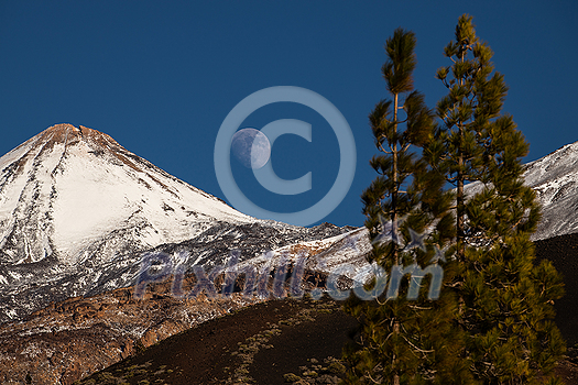 Colorful scenic landscape of moon rise in Tenerife national park of Teide. El Teide with moon rising by its side.