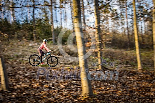 Pretty, young woman with her mountain bike going for a ride past the city limits, getting the daily cardio dose - close-up portrait (motion blurred image) Pretty, young woman with her mountain bike going for a ride past the city limits, getting the daily cardio dose - close-up portrait (motion blurred image)