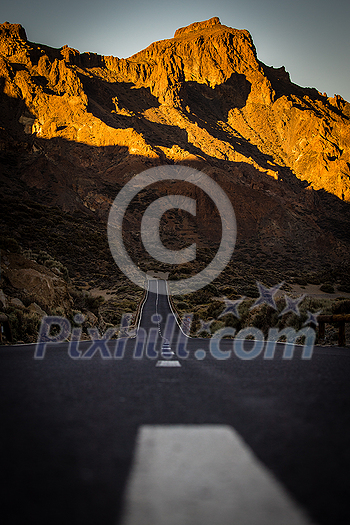 Long road in a mountain valley with a car on it - Teide National Park, Tenerife, Canary islands Long road in a mountain valley with a car on it - Teide National Park, Tenerife, Canary islands