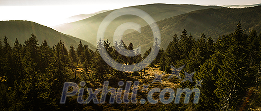 Mountain atmospheric landscape of high mountains in thick fog in rainy weather, panorama of mountain tops in thick clouds, dawn in the mountains in early spring.