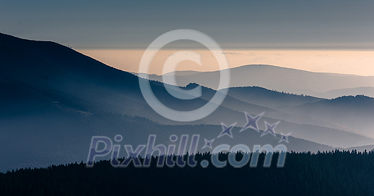 Mountain atmospheric landscape of high mountains in thick fog in rainy weather, panorama of mountain tops in thick clouds, dawn in the mountains in early spring. Mountain atmospheric landscape of high mountains in thick fog in rainy weather, panorama of mountain tops in thick clouds, dawn in the mountains in early spring.