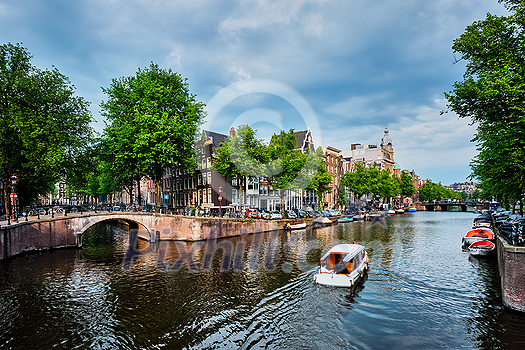Amsterdam view - canal with tourist boat, bridge and old houses. Amsterdam, Netherlands Amsterdam view - canal with tourist boat, bridge and old houses. Amsterdam, Netherlands
