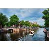 Amsterdam view - canal with tourist boat, bridge and old houses. Amsterdam, Netherlands