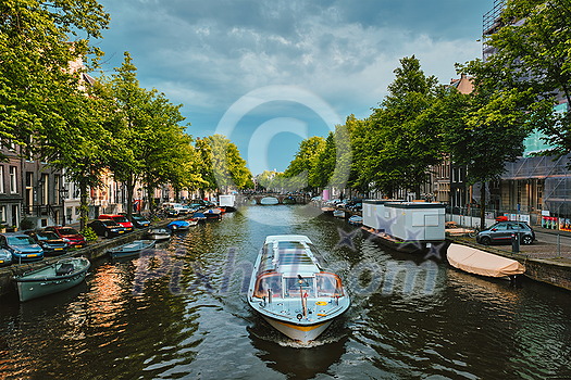 Amsterdam view - canal with tourist boat, bridge and old houses. Amsterdam, Netherlands Amsterdam view - canal with tourist boat, bridge and old houses. Amsterdam, Netherlands
