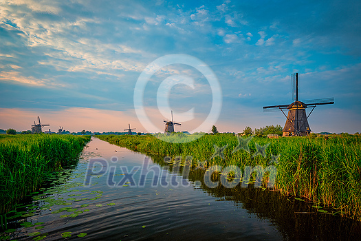 Netherlands rural landscape with windmills at famous tourist site Kinderdijk in Holland on sunset with dramatic sky