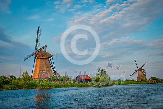 Netherlands rural lanscape with windmills at famous tourist site Kinderdijk in Holland on sunset with dramatic sky