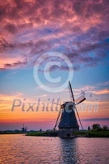 Netherlands rural landscape with windmills at famous tourist site Kinderdijk in Holland on sunset with dramatic sky