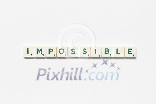 Impossible word formed of scrabble tiles on white background. Simple creative backdrop for business presentation.