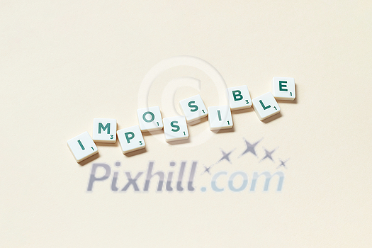 Impossible word formed of scrabble tiles on beige background. Simple creative backdrop for business presentation.
