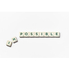 Impossible turning into Possible word made of scrabble blocks with on white background.