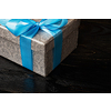 Gift birthday Christmas present concept - silver gift box with blue ribbon on dark wooden background