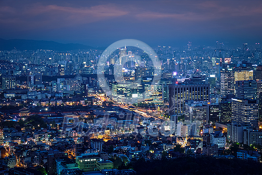 Seoul downtown cityscape illuminated with lights and Gyeongbokgung Palace in the evening view from Inwang mountain. Seoul, South Korea. Seoul downtown cityscape illuminated with lights and Gyeongbokgung Palace in the evening view from Inwang mountain. Seoul, South Korea.