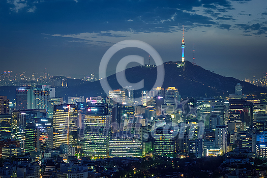Seoul downtown cityscape illuminated with lights and Namsan Seoul Tower in the evening view from Inwang mountain. Seoul, South Korea.