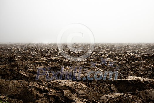 Fertile, dark soil, field after plowing. Getting ready for the next growing season being turned by plowing Fertile, dark soil, field after plowing. Getting ready for the next growing season being turned by plowing