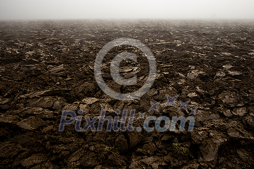 Fertile, dark soil, field after plowing. Getting ready for the next growing season being turned by plowing