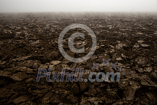Fertile, dark soil, field after plowing. Getting ready for the next growing season being turned by plowing Fertile, dark soil, field after plowing. Getting ready for the next growing season being turned by plowing