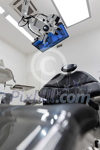 Dental treatment clinic interior with modern patient chair and a TV above Dental treatment clinic interior with modern patient chair and a TV above