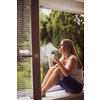 Mid-aged woman lighting a cigarette at home, getting her nicotine daily dose, unable to resist to her unhealthy habit