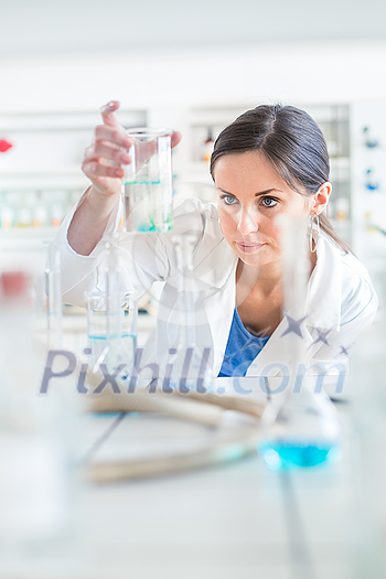 Young, female researcher carrying out experiments in a lab (shallow DOF; color toned image)
