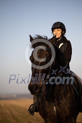 Female horse rider riding outdoors on her lovely horse Female horse rider riding outdoors on her lovely horse