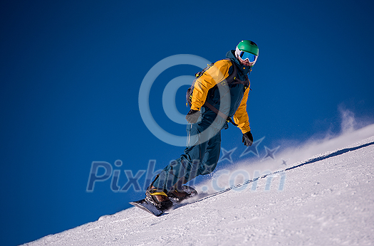 Young freestyle snowboarder running down the slope and ride free style at sunny winter day on Alpine mountains. Winter sport and recreation, leisure outdoor activities.