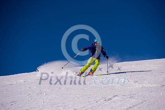 young athlete freestyle Skier having fun while running downhill in beautiful Alpine landscape on sunny day during winter season