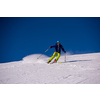 young athlete freestyle Skier having fun while running downhill in beautiful Alpine landscape on sunny day during winter season