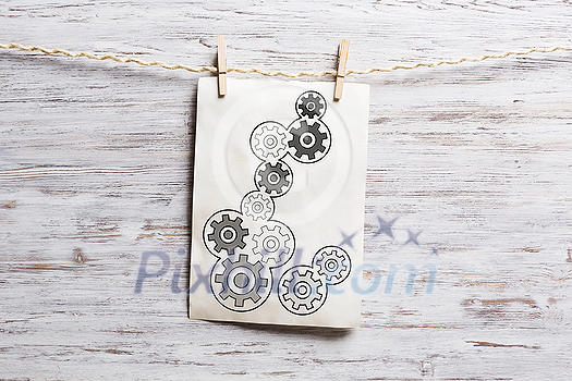 Paper sheet with sketches hanging on rope. Mixed media Paper sheet with sketches hanging on rope. Mixed media