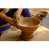 Pottery - skilled wet hands of potter shaping the clay on potter wheel. Pot, vase throwing. Manufacturing traditional handicraft Indian bowl, jar, pot, jug. Shilpagram, Udaipur, Rajasthan, India