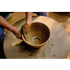 Pottery - skilled wet hands of potter shaping the clay on potter wheel. Pot, vase throwing. Manufacturing traditional handicraft Indian bowl, jar, pot, jug. Shilpagram, Udaipur, Rajasthan, India