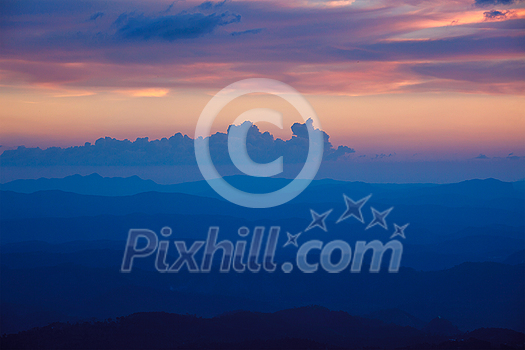 Silhouettes of hills in valley on sunset. Pothamedu viewpoint, Munnar, Kerala, India