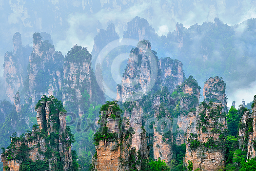 Famous tourist attraction of China - Zhangjiajie stone pillars cliff mountains in fog clouds at Wulingyuan, Hunan, China Famous tourist attraction of China - Zhangjiajie stone pillars cliff mountains in fog clouds at Wulingyuan, Hunan, China