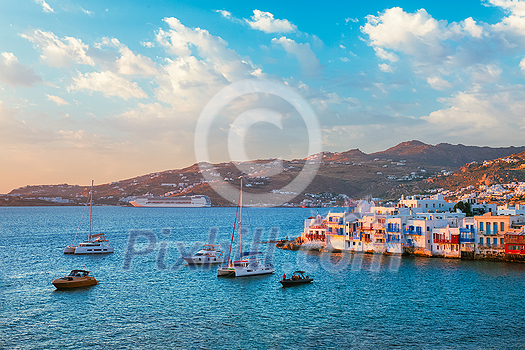 Sunset in Mykonos island, Greece with yachts in the harbor and colorful waterfront houses of Little Venice romantic spot on sunset with cruise ship and yacht boats. Mykonos townd, Greece Sunset in Mykonos island, Greece with yachts in the harbor and colorful waterfront houses of Little Venice romantic spot on sunset with cruise ship and yacht boats. Mykonos townd, Greece