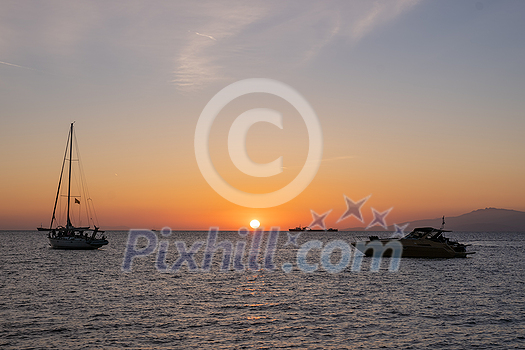 Sunset in Mykonos island, Greece with yachts in the harbor romantic spot on sunset. Mykonos town, Greece