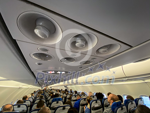 Cabin of a modern airplane filled with passangers to its full capacity during flight, after delayed departure (shallow DOF) Cabin of a modern airplane filled with passangers to its full capacity during flight, after delayed departure (shallow DOF)