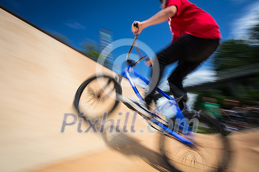 Bmx rider jumping over on a U ramp in a skatepark (motion blurred image) Bmx rider jumping over on a U ramp in a skatepark (motion blurred image)