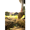 Senior gardener gardening in his permaculture garden - using a spade