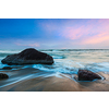 Tropical beach vacation background - waves and rocks on beach of sunset